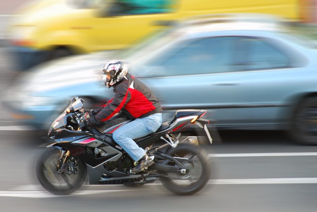 motorcycle zips by car